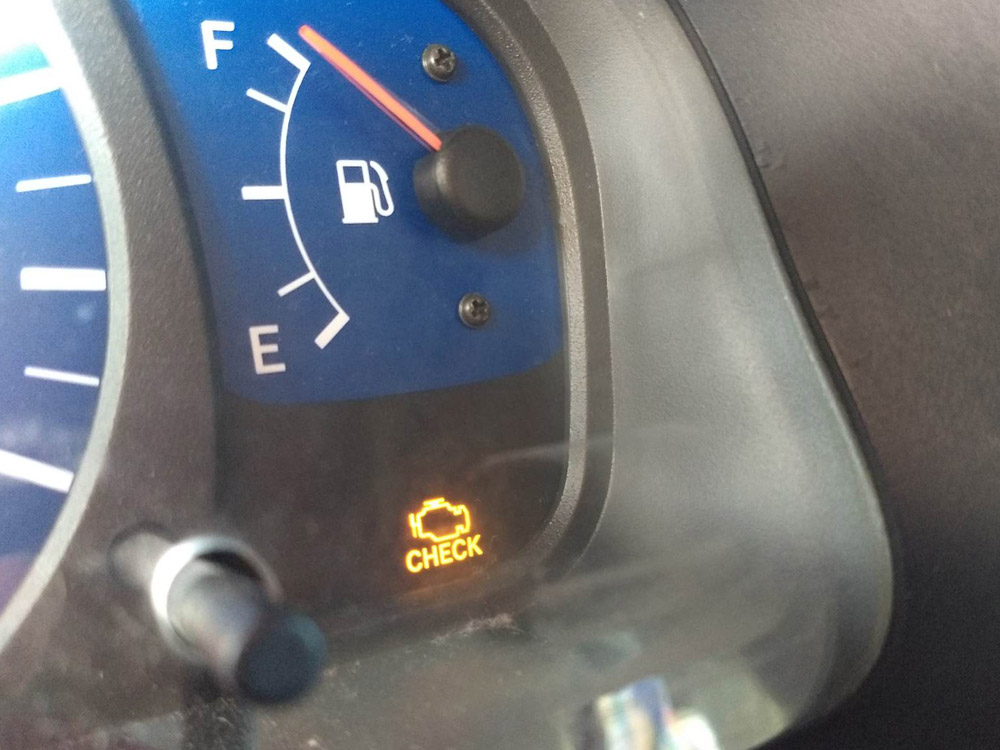 illuminated check engine light on car dashboard